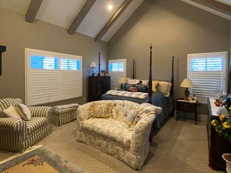 Bedroom with windows featuring Hunter Douglas blinds.